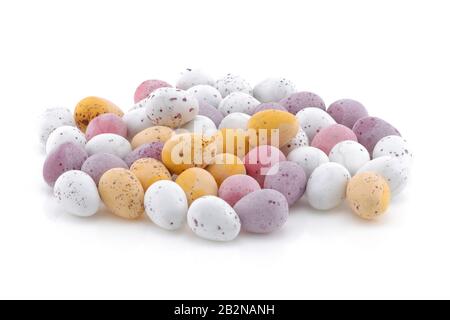 A selection of Yellow pink purple and white Easter candy eggs isolated on a white background Stock Photo