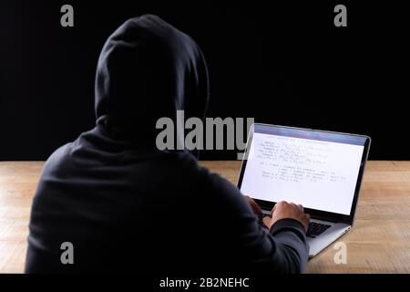 Caucasian man working on laptop on black background Stock Photo