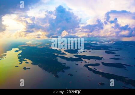 Dramatic sunset skies over Swedish coastline of Baltic Sea seen from a flying plane to Scavsta Airport just after a summer storm passing Stock Photo
