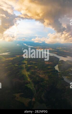 Aerial view of Swedish scountryside with farmlands,green forests and wheat fields seen from flying plane to Scavsta Airport after summer storm passing Stock Photo