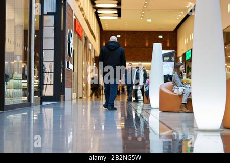 02-03-2020 Riga, Latvia Wide hall and buyers in trading center with shops on both sides. Stock Photo