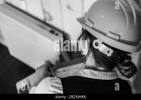 close up and selective focus, rear view of inspector woman, inspecting a modern eco energy efficient house. black and white with copy space. Stock Photo