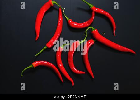 Red hot chilly peppers on dark backdrop Stock Photo