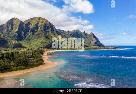 Aerial shot off the coast over Tunnels beach on Hawaiian island of Kauai with Na Pali mountains behind Stock Photo