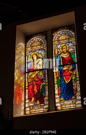 Sun light streaming through stained glass windows with pictures of Saint John, San Juan, and Saint Mark, San Marco, in the church of Nuestra Senora de Stock Photo
