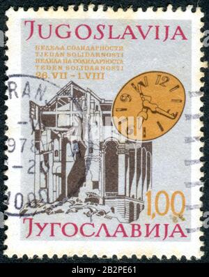 YUGOSLAVIA - CIRCA 1980: A charity stamp printed in Yugoslavia, depicted destroyed building and the dial (Solidarity week), circa 1980 Stock Photo