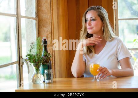 A woman enjoying a delicious IPA wheat NEIPA craft beer pint in a tulip glass at a bar, pub, restaurant, during weekend Stock Photo