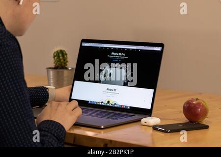 Man looking at the latest Apple smartphones, the iPhone 11 and iPhone 11 Pro on Apple's website. Stock Photo