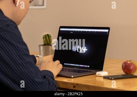 Man looking at the new Apple TV + streaming service on the Apple website. Stock Photo