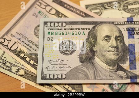 United States Federal Reserve System crest in focus on the 100 dollar note, on a pile of American dollar (USD). Stock Photo