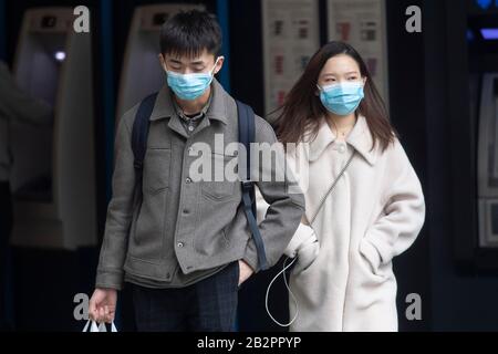London, Britain. 3rd Mar, 2020. A man and a woman wearing face masks walk past a store in central London, Britain, on March 3, 2020. British Prime Minister Boris Johnson on Tuesday set out the government's action plan to tackle the spread of the novel coronavirus, as the number of infections reached 51 across the country. Credit: Ray Tang/Xinhua/Alamy Live News Stock Photo