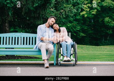 beautiful disabled woman with happy boyfriend resting in park together Stock Photo