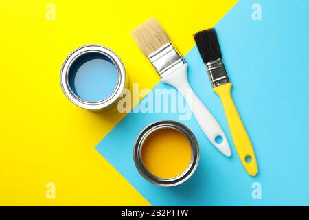 Cans with paint and brushes on two tone background, top view Stock Photo