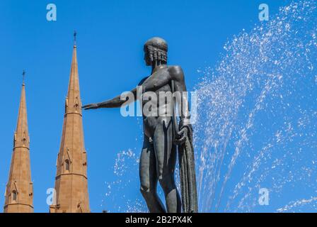 Sydney, Australia - December 11, 2009: Closeup of Apollo statue at Archibald fountain in full operation. Spouting water, Saint Mary Cathedral and blue Stock Photo