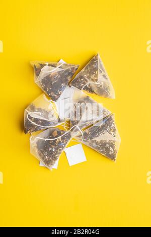 Floral tea bags on yellow background. Top view. Stock Photo