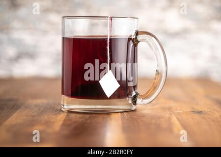 Fruit tea in glass mug on wooden table. Stock Photo