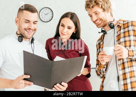 happy brokers looking at folder and smiling in call center Stock Photo