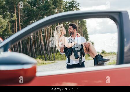 handsome man holding attractive and blonde woman in dress Stock Photo