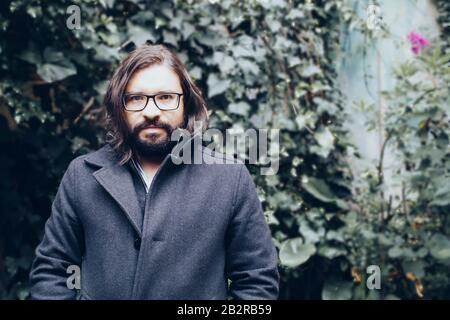 Bearded man in a black jacket looking determined Stock Photo