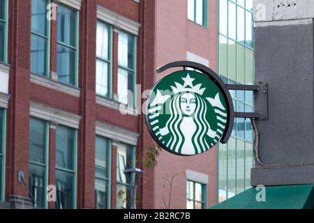 Starbucks Coffee sign hanging at the front of one of their locations in a large cities, downtown core. Stock Photo