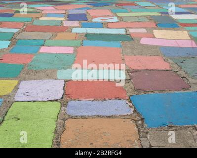 Colourfully painted stone slabs in different sizes with concrete joints Stock Photo