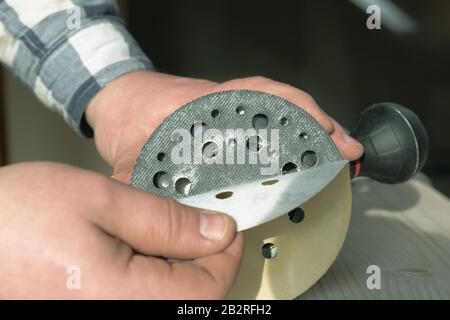 Carpentry. Wood sanding. Orbital sander for woodworking. In a natural light Stock Photo