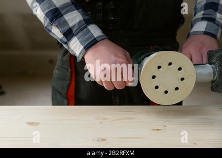 Carpentry. Wood sanding. Orbital sander for woodworking. In a natural light Stock Photo