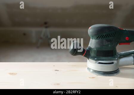 Carpentry. Wood sanding. Orbital sander for woodworking. In a natural light Stock Photo