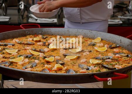 chef cooking Spanish paella in outdoor area Stock Photo