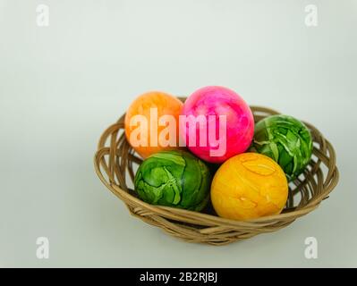 Five coloured Easter eggs in a small woven basket Stock Photo