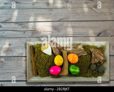 Easter decoration in a wooden bowl on old wooden boards Stock Photo