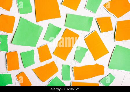 Torn paper on a white background. Green and orange pieces of colored paper. Abstract colorful background Stock Photo