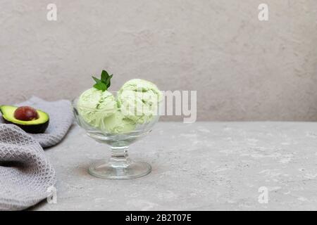 Scoops of green avocado ice cream on neutral background. Image with copy space Stock Photo