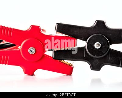 Closeup of black and red jumper cable clamps shot over white Stock Photo