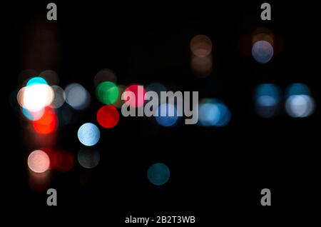 abstract bokeh background in the form of multi -colored circles on a black background. Stock Photo