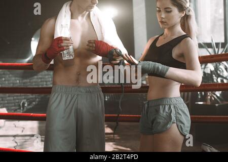 Boxing coach talking to female boxer sitting in boxing ring Stock Photo ...