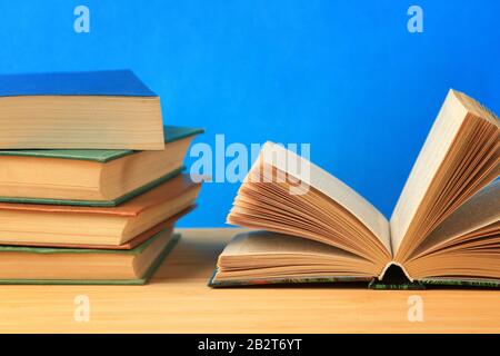 Open antique book on wooden table on wall background Stock Photo