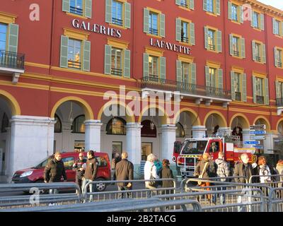 A fire truck is parked outside Galeries Lafayette and onlookers gather in the Place Massena before the closing ceremony of carnival 2020 Stock Photo