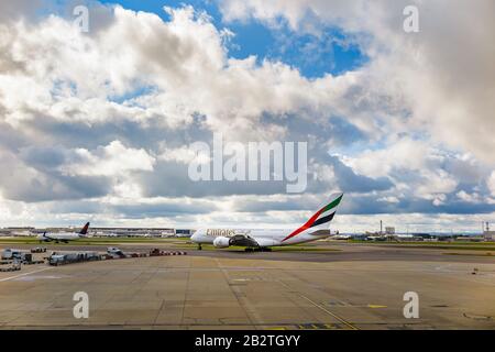 Emirates Airbus A380-861 in corporate livery standing on the runway at London Heathrow Airport on the runway awaiting take-off under dark heavy clouds Stock Photo