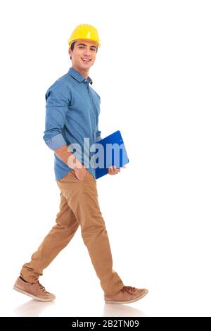 side view of a smiling construction engineer smiling to the camera on white background, full body picture Stock Photo