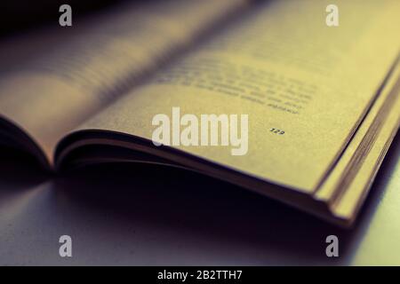 Open book on the table. Closeup, side view. Stock Photo