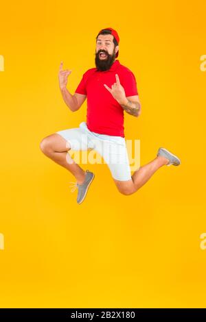 Energy charge. Healthy guy feeling good. Inspired concept. Always in motion. Enjoying active lifestyle. Happy guy jumping. Active bearded man in motion yellow background. Active and energetic hipster. Stock Photo