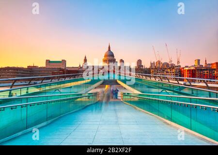 Blurred motion view over the Millennium footbridge looking towards St. Paul's Cathedral at sunset Stock Photo