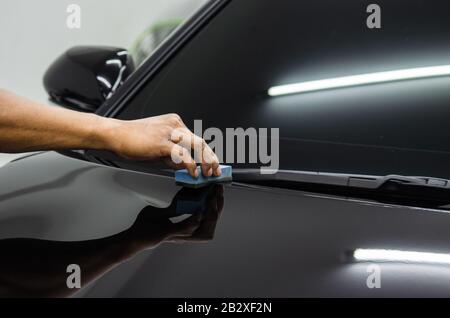 mechanic is coating ceramic glass to prevent scratches on cars. Stock Photo