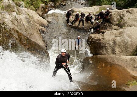 Adult Man Descending An Ecuadorian Waterfall In A Correct Position Stock Photo