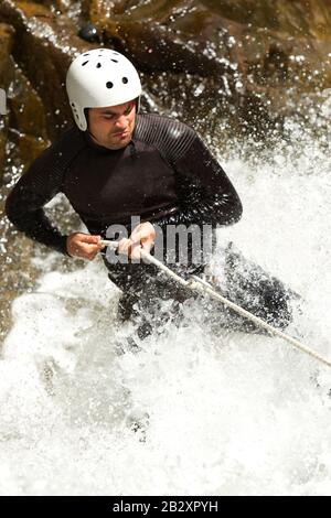 Adult Man Descending An Ecuadorian Waterfall In A Correct Position Stock Photo