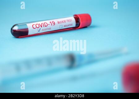 Test tube with blood sample for COVID-19 test, novel coronavirus 2019 found in Wuhan, China. Coronavirus disease: COVID-19. Blue background