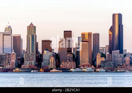 Ferries and other passenger ships are standing at the pier on the waterfront with high-rise buildings of the down town of Seattle in the bay on the Pa Stock Photo