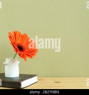 Vintage diary with gerbera flower on wooden table with khaki background. copy space Stock Photo