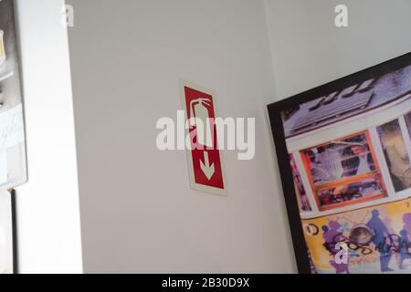 Fire extinguisher marker on white wall in restaurant area Stock Photo